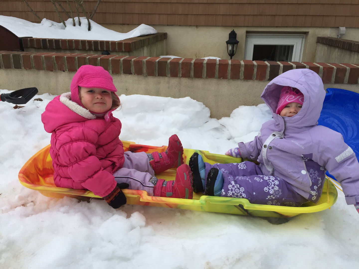 Two toddlers playing in the snow