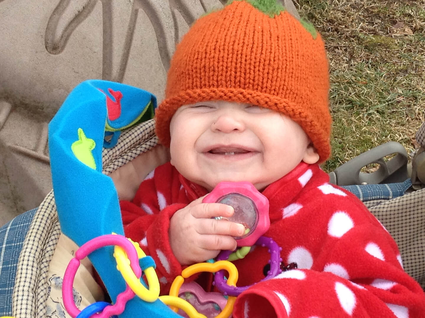 Smiling toddler wearing an orange beanie