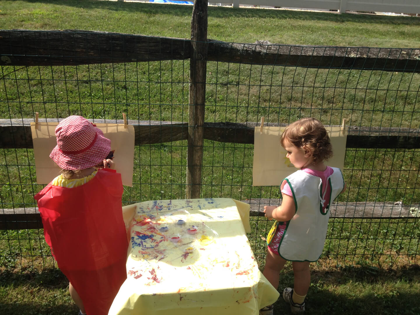 Two young girls painting outside