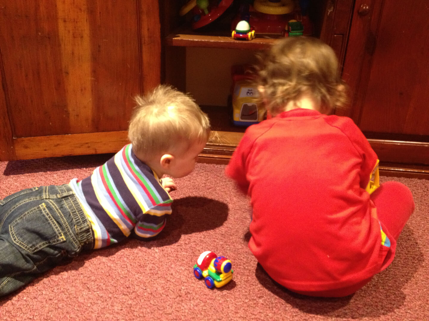 Two kids playing with toy cars